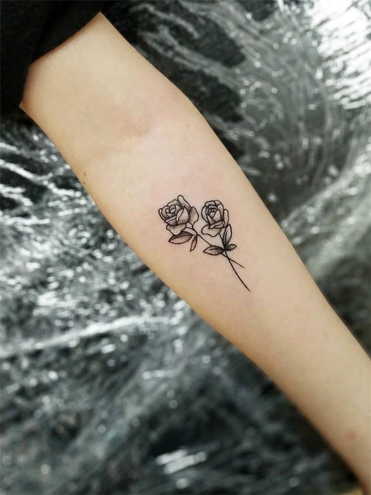 2 Black and grey rose tattoos on forearm